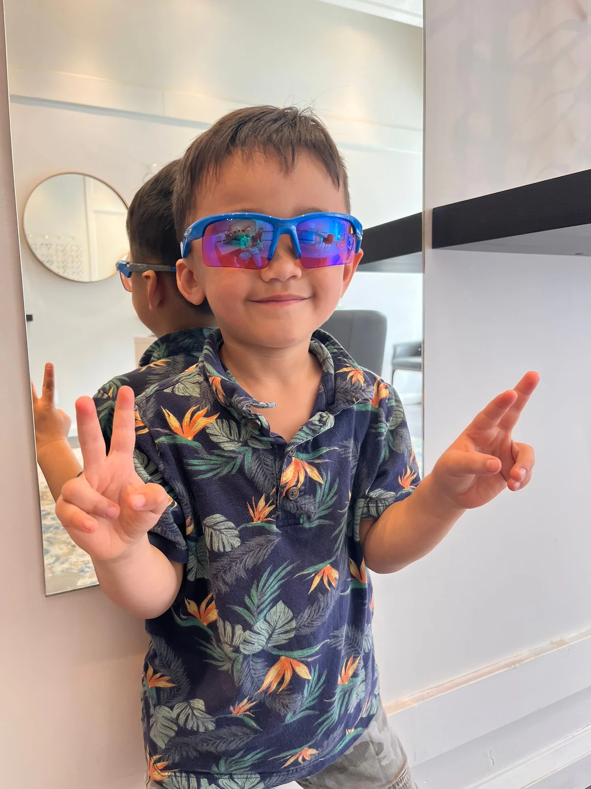 Smiling child trying on sunglasses at Boardwalk Eye Care