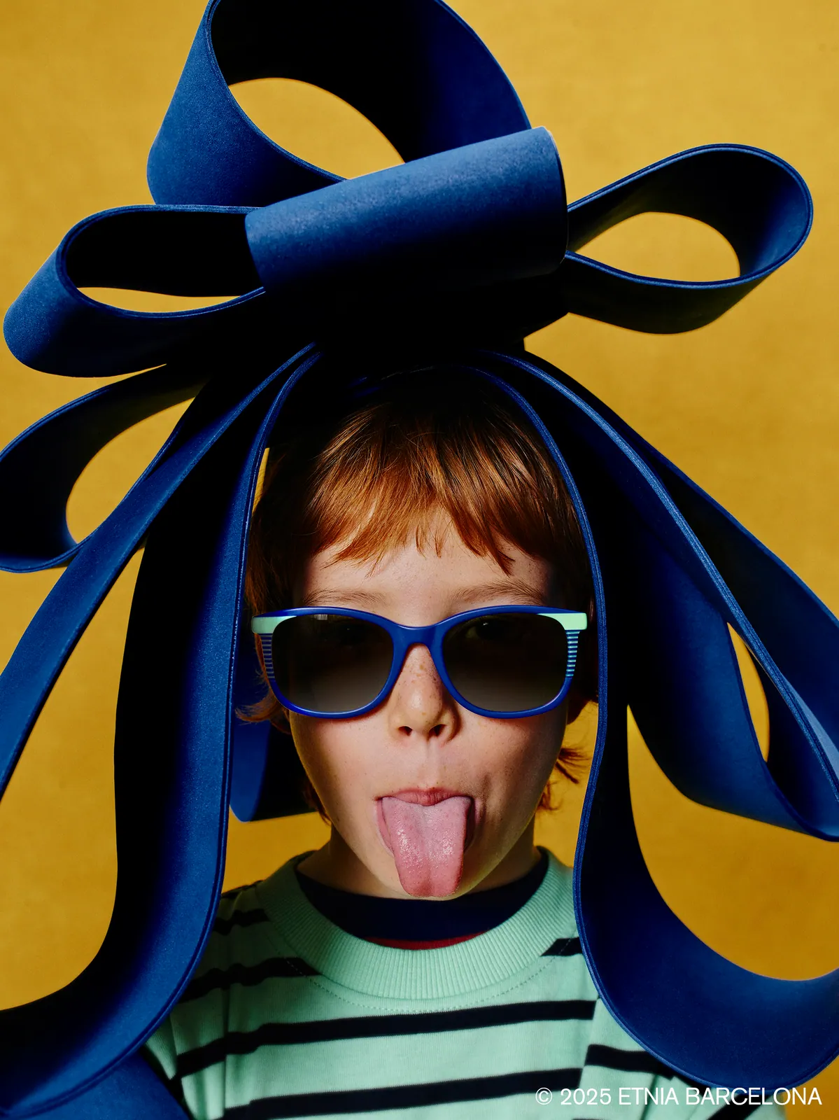 Boy in bunny ears wearing dark-framed Etnia Barcelona kids' glasses, available at Boardwalk Eye Care in Cambridge, Ontario