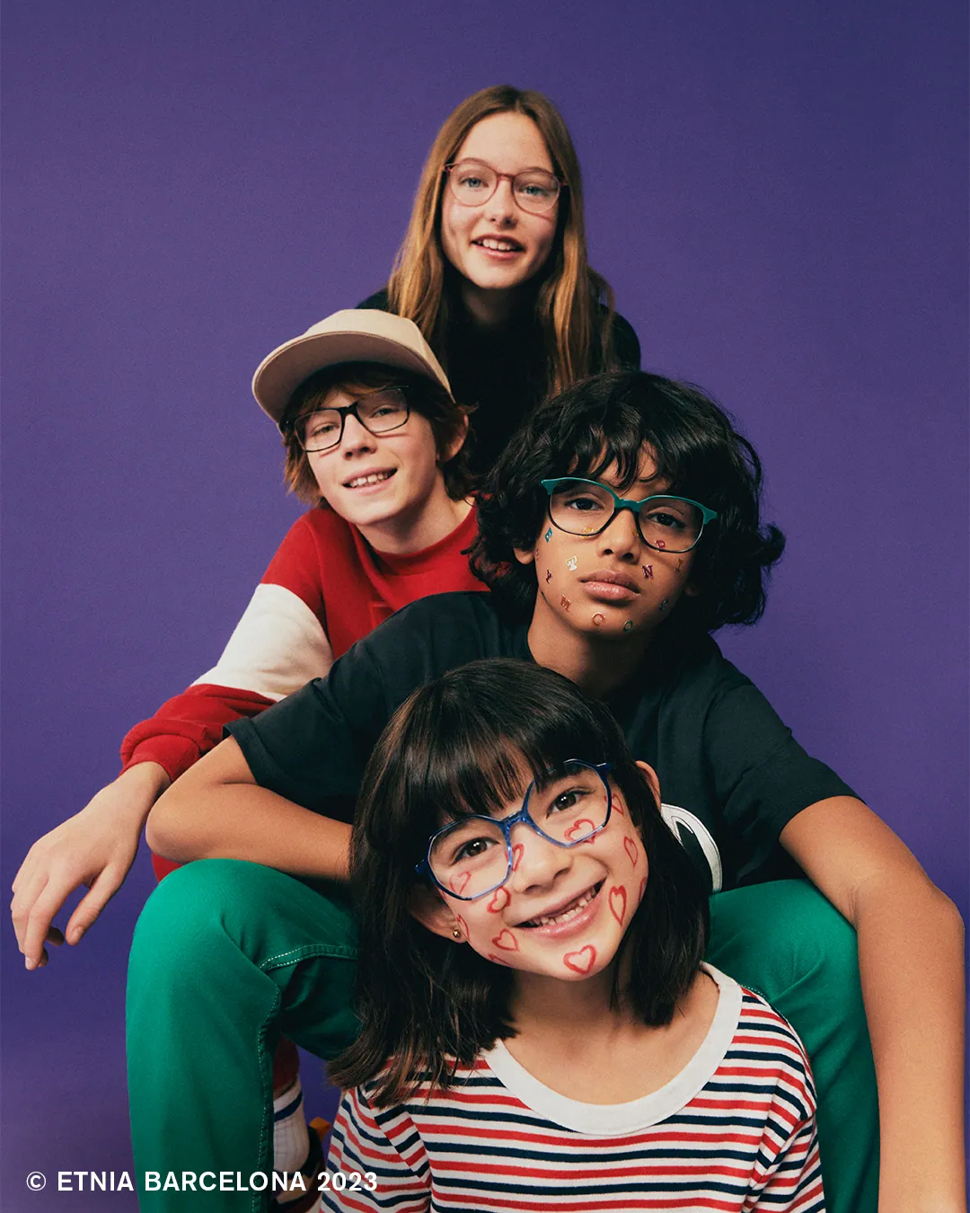 Four children wearing Etnia Barcelona kids' glasses, available at Boardwalk Eye Care in Cambridge, Ontario