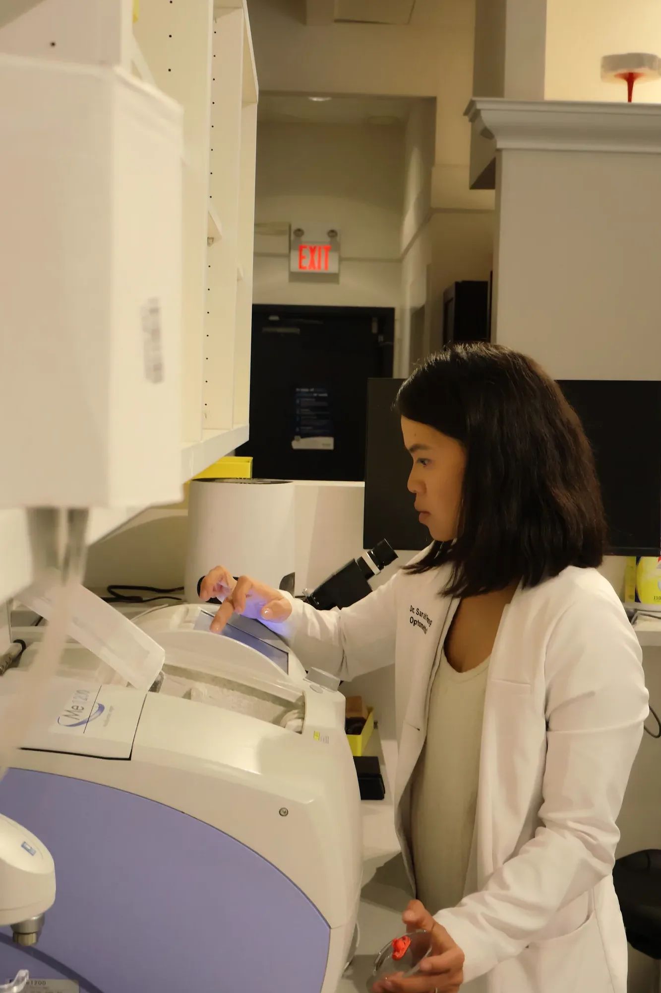 Dr. Sarah Fong cutting a lens at Boardwalk Eye Care's in-store lab in Cambridge
