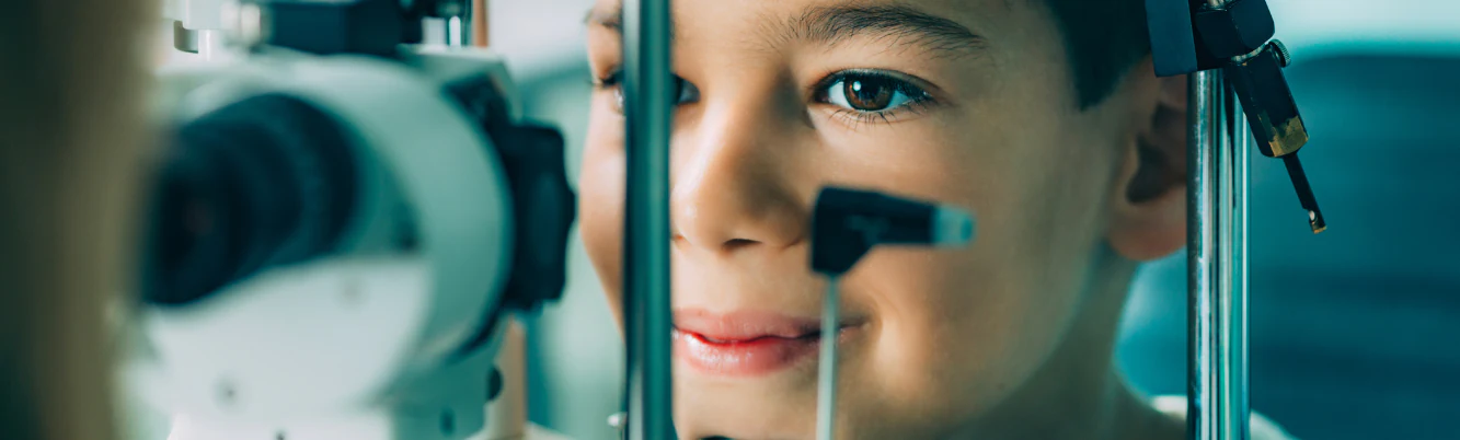 Child having their eyes examined with pediatric eye-care equipment